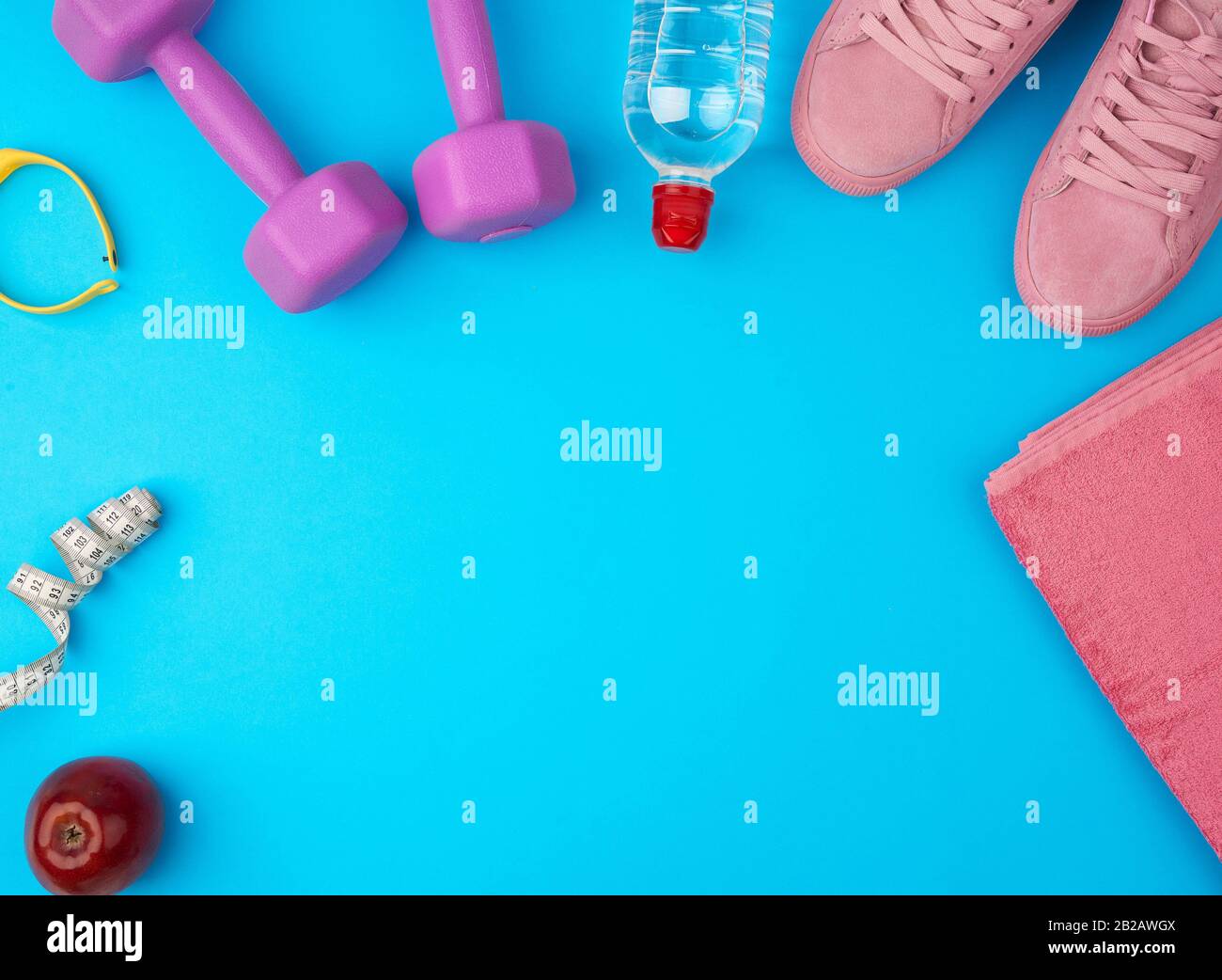 mancuernas de plástico púrpura, ropa deportiva, agua, sneakers de color  rosa sobre fondo azul, kit de fitness, diseño plano, espacio para copias  Fotografía de stock - Alamy