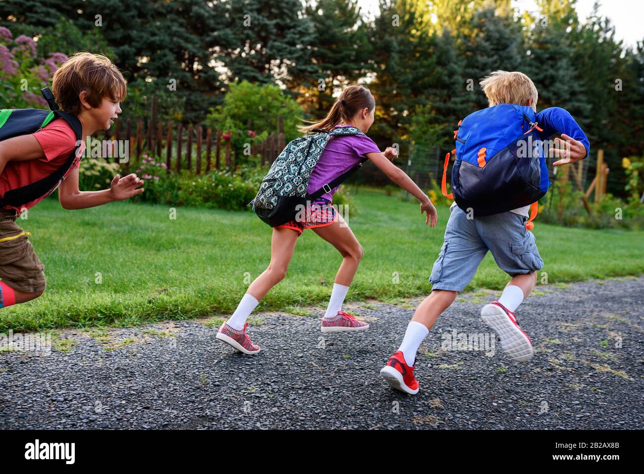Tres niños corriendo a lo largo de un sendero, Estados Unidos Foto de stock