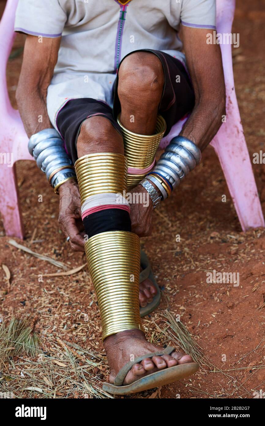 Kayan Lahwi mujer reajustando los anillos de latón que ella usa alrededor de sus piernas. El largo cuello Kayan (también llamado Padaung en birmano) son un subgrupo de la Foto de stock