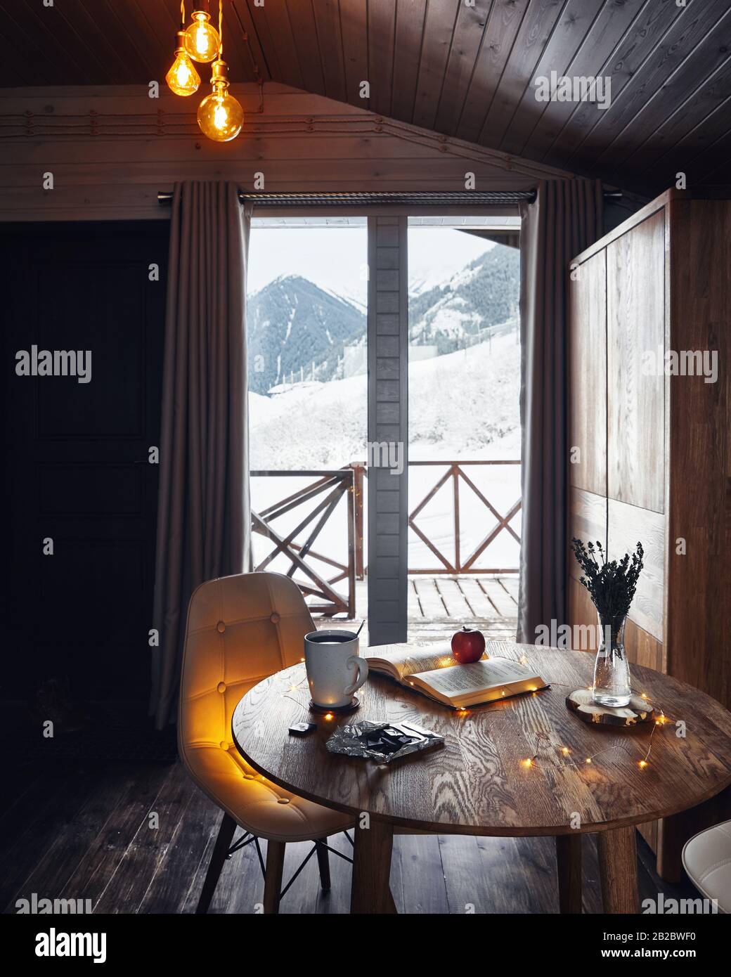 Loft interior con luces cálidas en madera chalet de invierno con hermosas  vistas a la montaña Fotografía de stock - Alamy