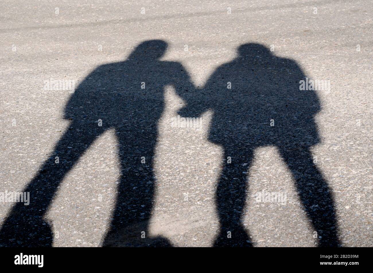 Serie de siluetas de jóvenes amantes. Serie 1. La sombra de los amantes de la mano al atardecer. Un chico y una niña están de pie cerca sosteniendo las manos. Sh Foto de stock