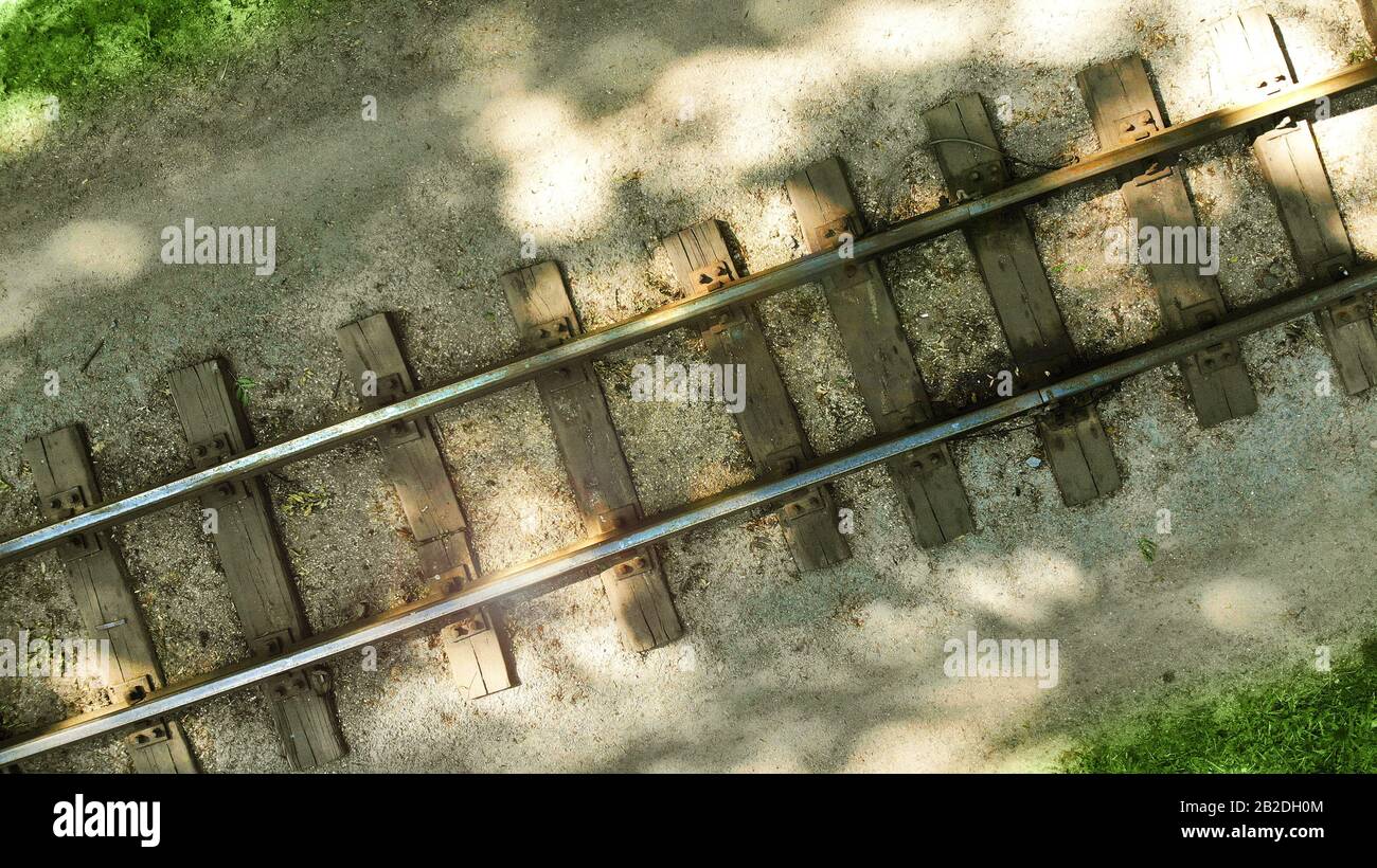 Foto aérea de un antiguo ferrocarril con traviesas de madera. Disposición diagonal de fondo con rieles. Foto de stock