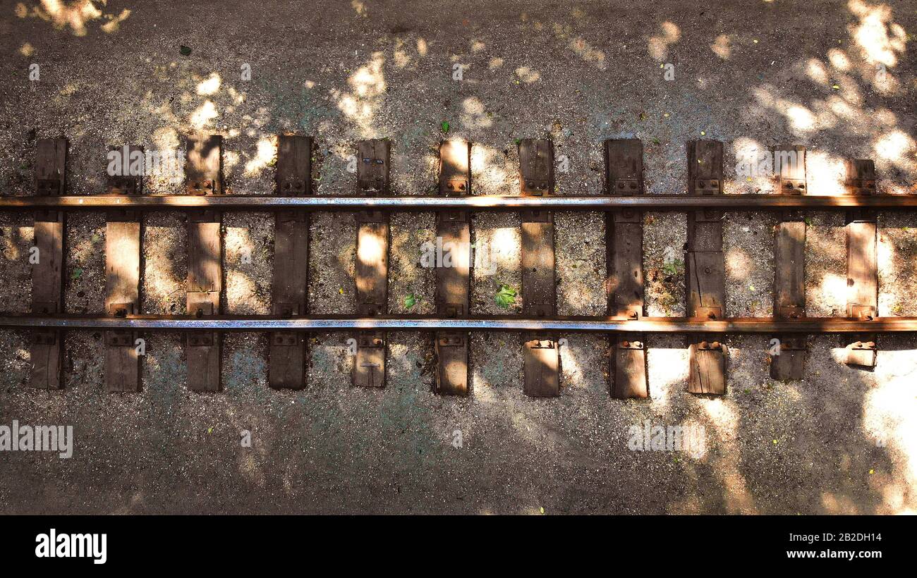 Foto aérea de un antiguo ferrocarril con traviesas de madera. Fondo con rieles. Foto de stock