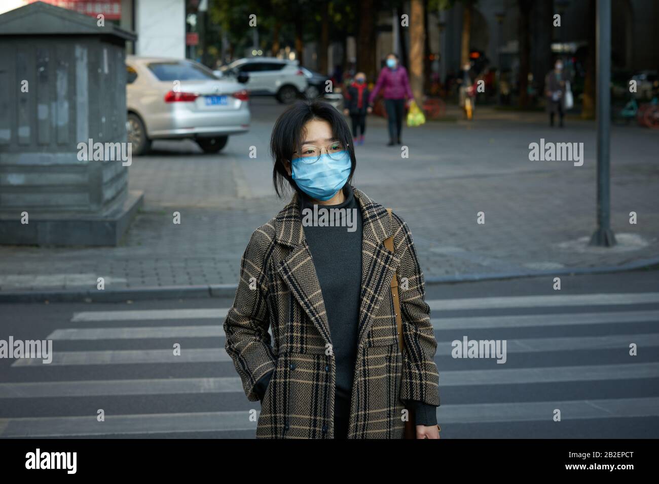 Durante el brote de enfermedad de coronavirus que se extiende al planeta, la gente está usando una máscara quirúrgica en la calle para prevenir la enfermedad de coronavirus. Foto de stock