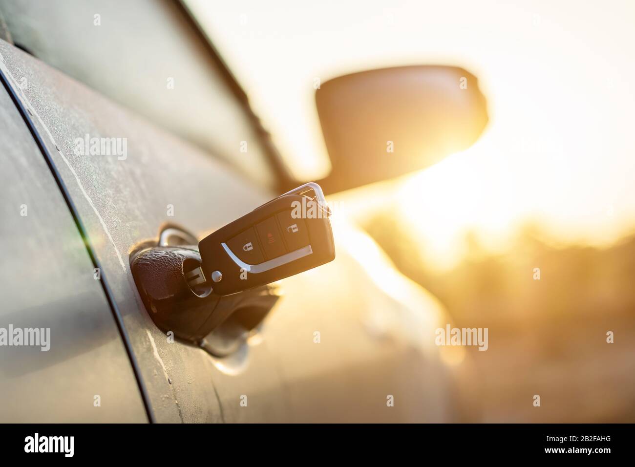 Olvídate del concepto clave: Las llaves del coche estaban enchufadas en la  puerta plateada del coche en el aparcamiento exterior con efecto de luz  solar por la mañana o al atardecer Fotografía