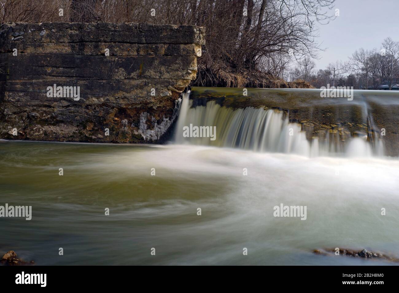 Una larga exposición del agua que fluye sobre la presa de la calle 10 en Logansport Indiana Foto de stock