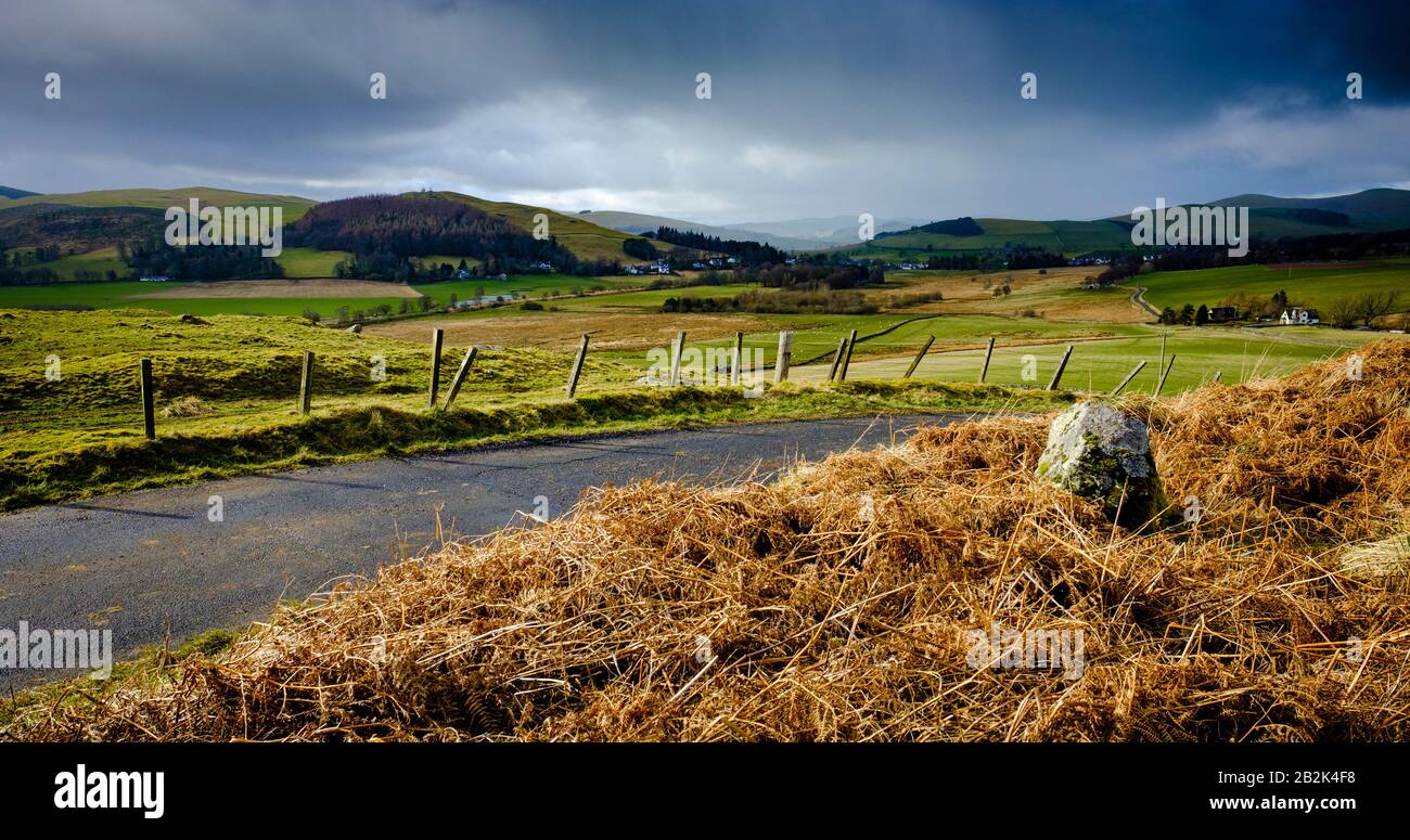 Lluvia y sol en las fronteras escocesas mirando hacia el pueblo de Broughton. Foto de stock