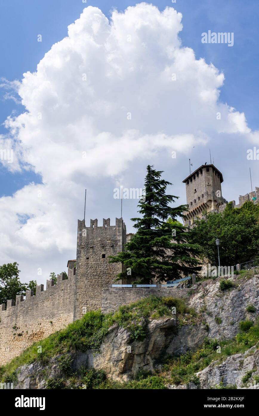 Murallas de piedra fortificadas y torres de castillo a lo largo de las montañas de San Marino en el sur de Europa Foto de stock