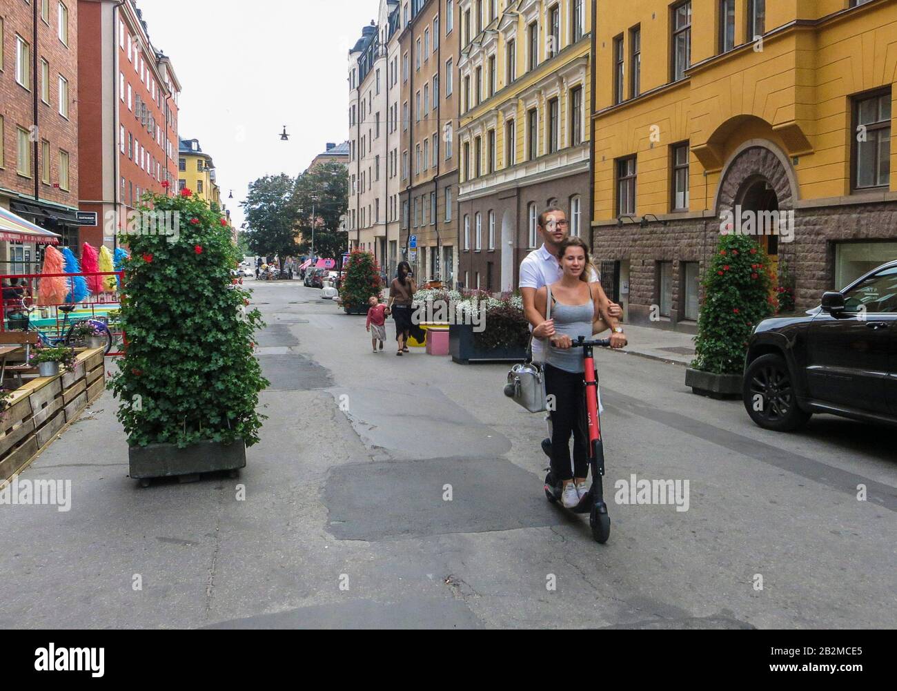 Una pareja en un scooter eléctrico patada en la cadera Distrito SOFO de Estocolmo Suecia Foto de stock