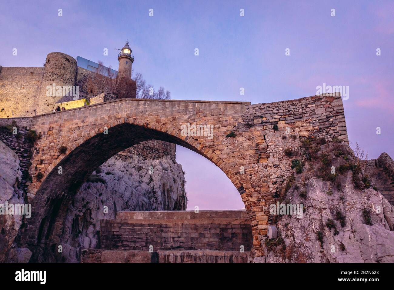 Puente antiguo frente al Castillo de Santa Ana en el puerto marítimo de Castro Urdiales en Cantabria Foto de stock