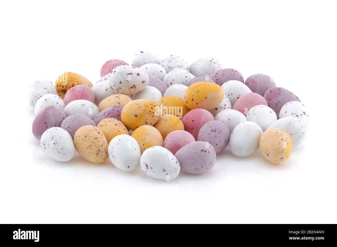 Una selección de huevos de caramelo de Pascua blancos y púrpura rosa amarillo aislados sobre un fondo blanco Foto de stock