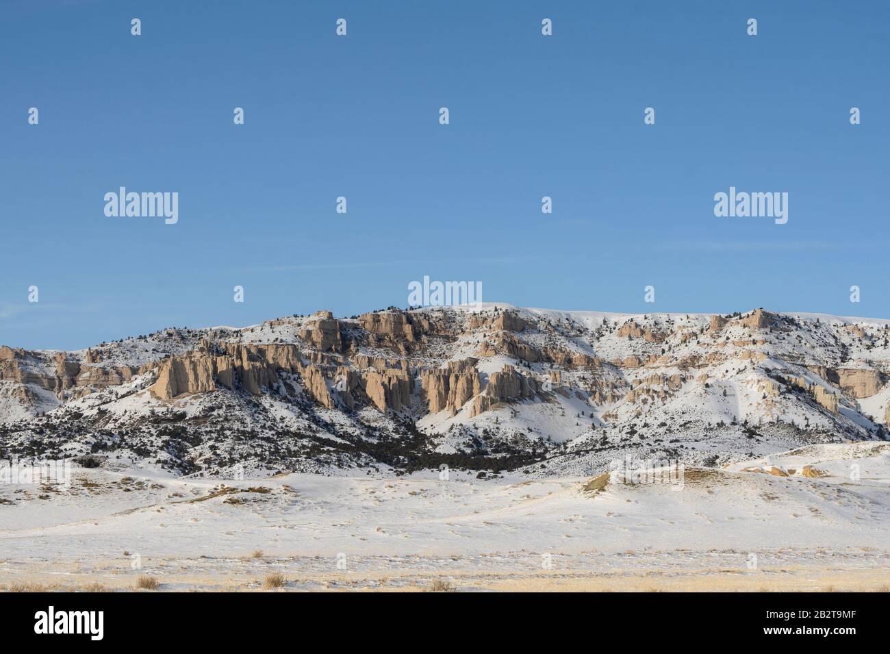 Wyoming paisaje de una colina nevada y afloramiento rocoso en una zona rural. Foto de stock