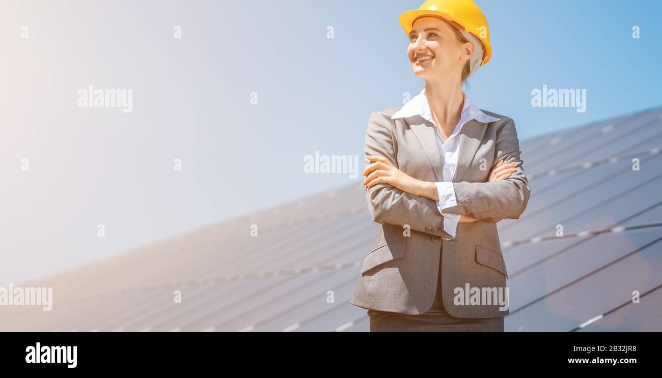 Mujer inversionista en energía limpia delante de paneles solares Foto de stock