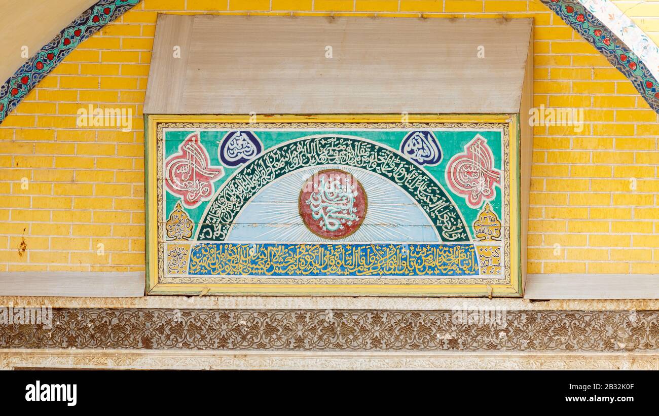 Primer plano de inscripción colorida en la puerta de entrada de La Mezquita Id Kah - una de las mezquitas más grandes de China, frecuentan Principalmente los musulmanes uigures. Foto de stock