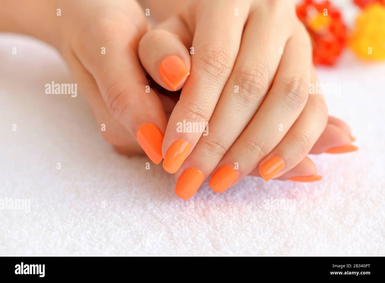 Mareo Perjudicial Asistente Manos de una mujer con manicura naranja en uñas sobre el fondo de una toalla  blanca Fotografía de stock - Alamy