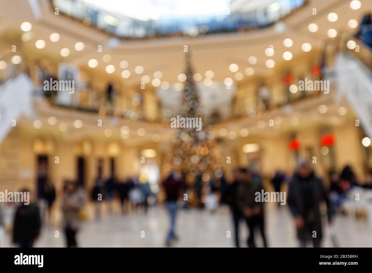 Clientes En Christmassy Shopping Mall Frente Al Árbol De Navidad Blurred De Fondo Foto de stock