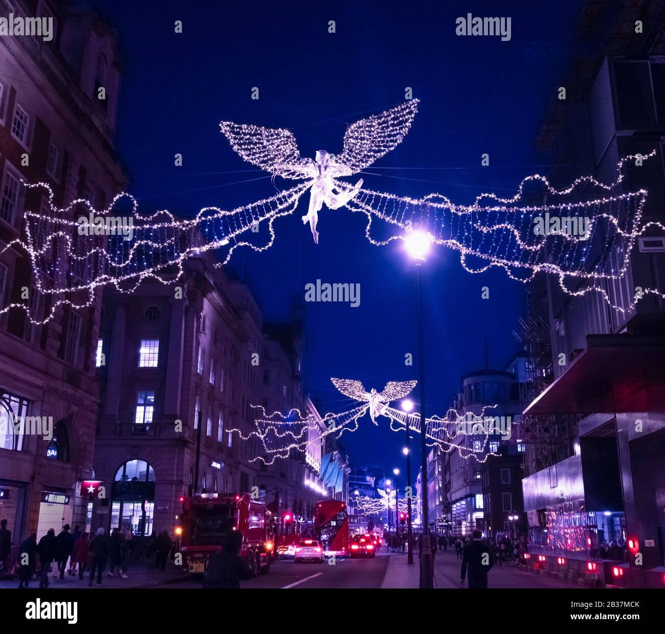 Una animada escena callejera por la noche durante el período festivo en Piccadilly, Londres, Reino Unido. Foto de stock