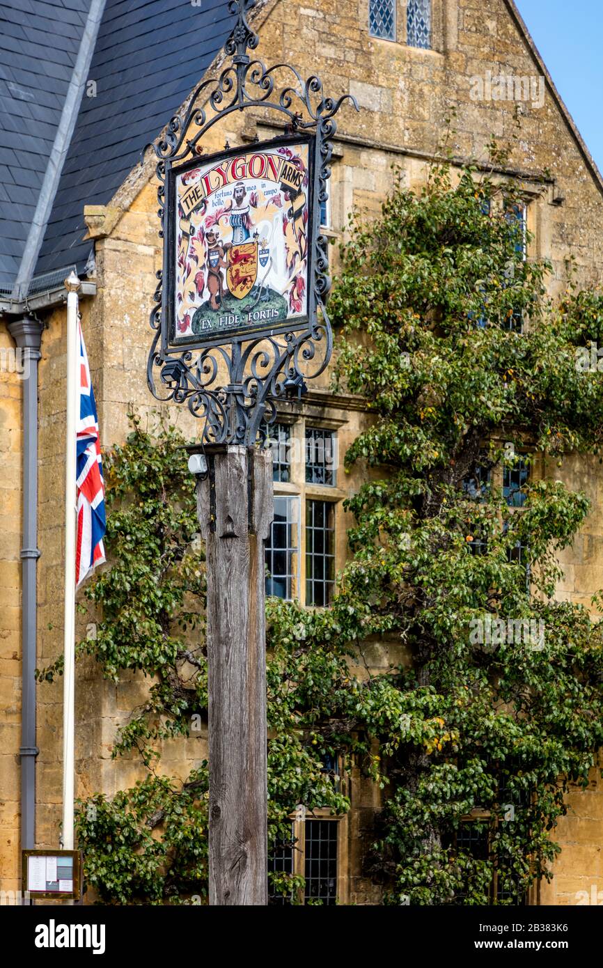 Poste de señal y fachada frontal del histórico Lygon Arms Hotel (circ. 1300), Broadway, Worcestershire, Inglaterra, Reino Unido Foto de stock