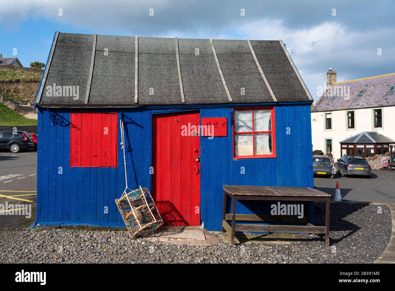 Colorida cabaña de madera junto al puerto en el pueblo pesquero de St Abbs en la costa del Mar del Norte en Scottish Borders, Escocia, Reino Unido Foto de stock