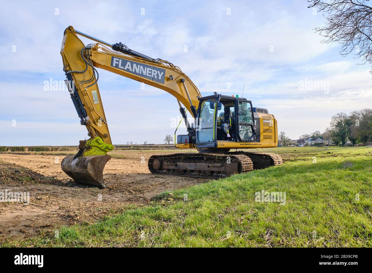 Una gran excavadora de cadenas CAT 360 operada por la planta de alquiler de Flannery en un campo de Lincolnshire que realiza obras de tierra antes de la puesta principal de agua Foto de stock