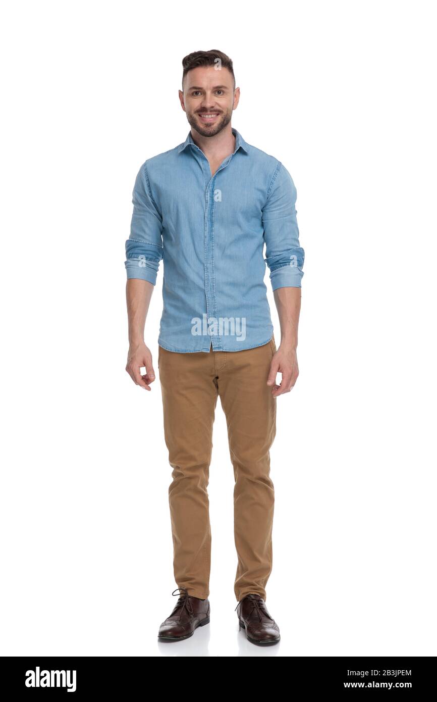 hombre elegante y casual con camisa azul está parado y mirando hacia  adelante feliz sobre fondo blanco del estudio Fotografía de stock - Alamy