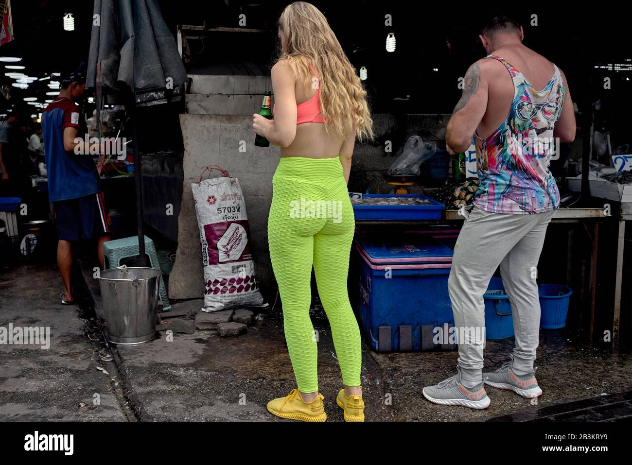 Leggings. Mujer con ropa colorida en la calle, incluyendo leggins verdes  luminosos, zapatillas amarillas y bikini rojo top.Thailand Sudeste Asiático  Fotografía de stock - Alamy