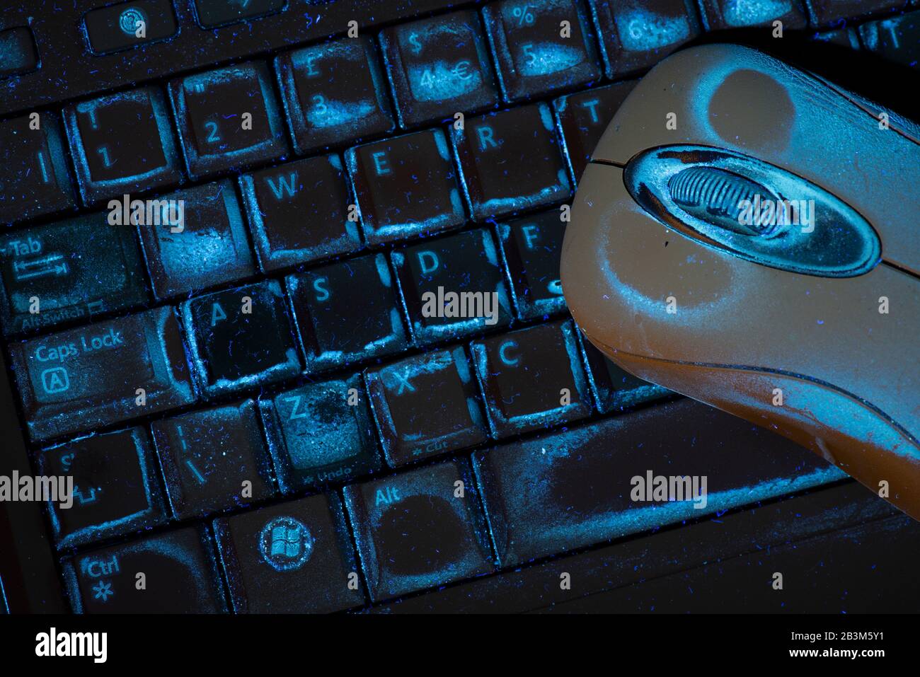 Suciedad en el teclado y el ratón del ordenador, visible y con luz UV Foto de stock