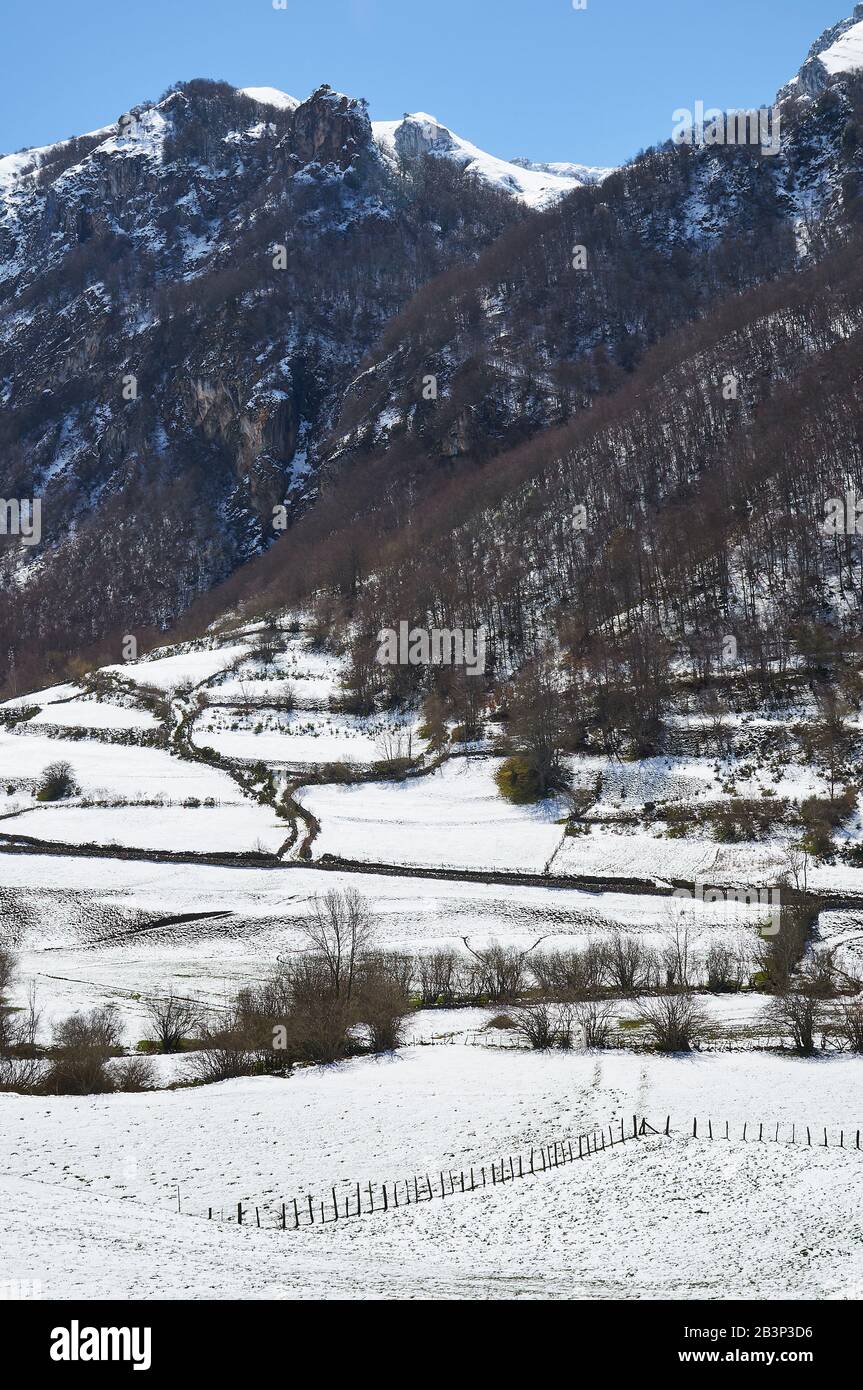 Paisaje nevado en Valle del Lago desde PR.AS-15 sendero con montañas nevadas en la distancia (Valle del Lago, Parque Natural de Somiedo, Asturias, España) Foto de stock