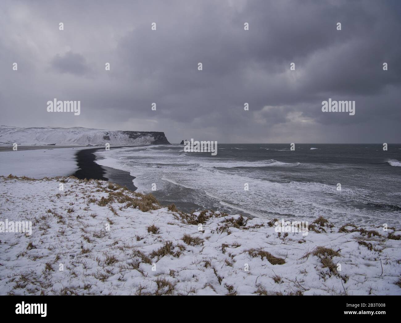 La costa nevada de Islandia con la playa de arena negra Foto de stock