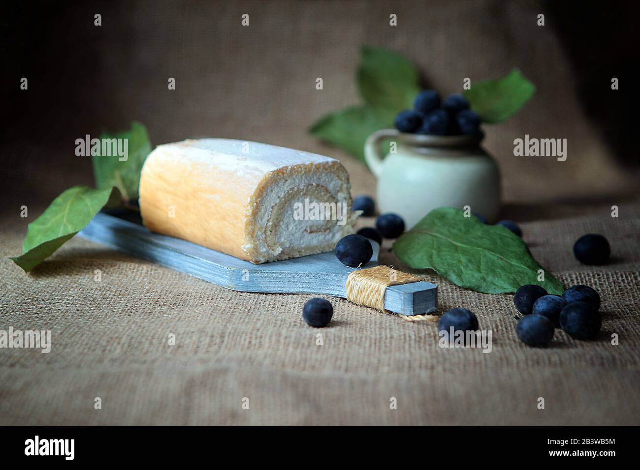 Sin cocción rollo cuajada pastel relleno con crema de coco y ciruelas Foto de stock