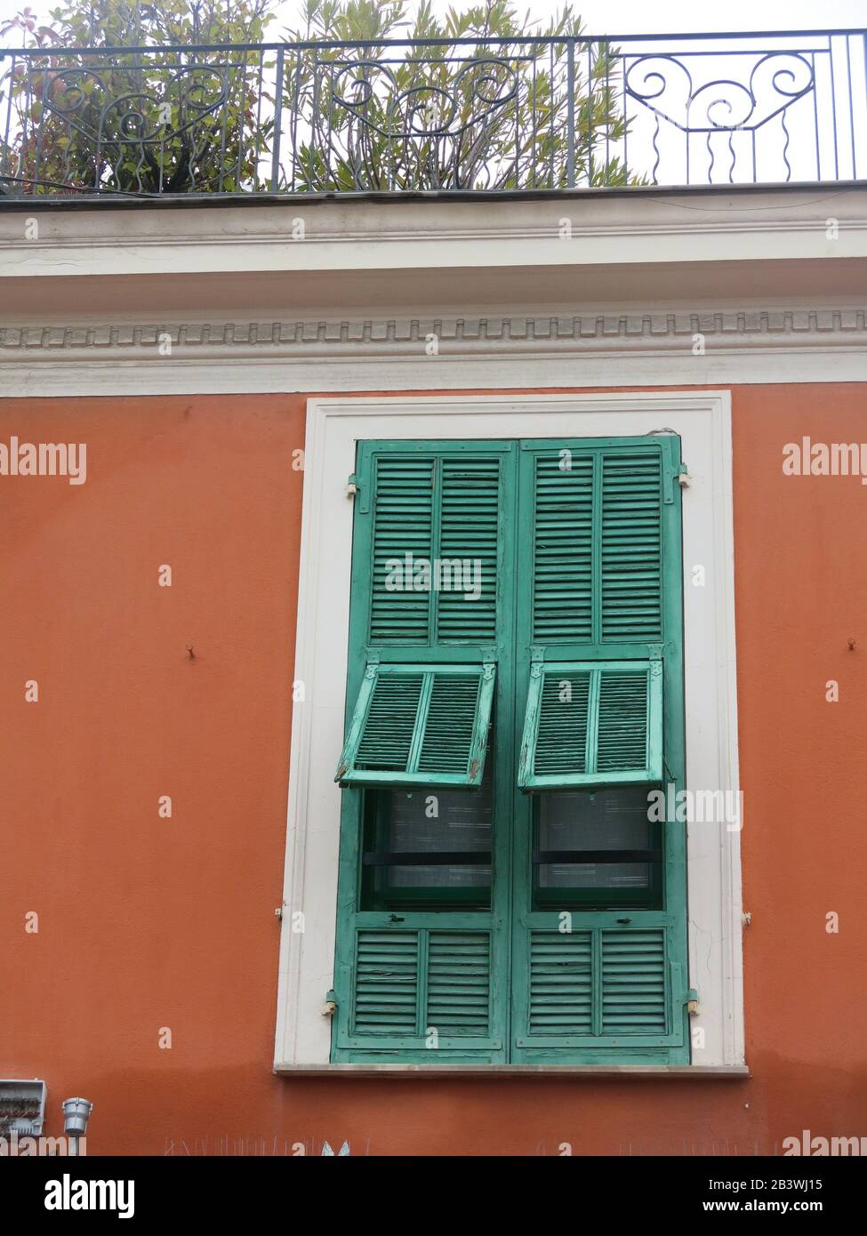 Arquitectura de estilo mediterráneo con persianas de madera en todas las  ventanas y colores que se representan en los edificios Fotografía de stock  - Alamy