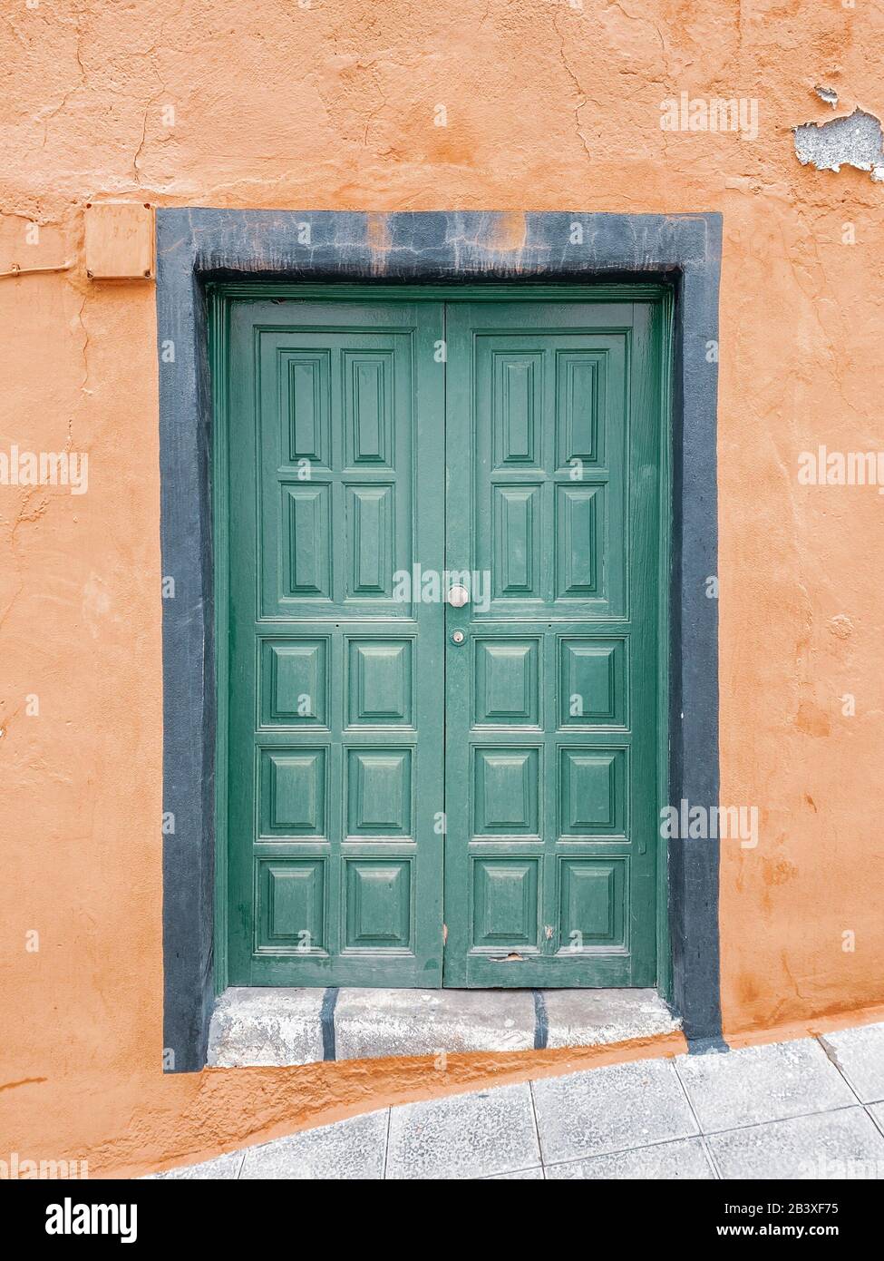 Puerta de madera de época pintada en verde en la fachada del edificio. Imagen realizada en el teléfono móvil Foto de stock