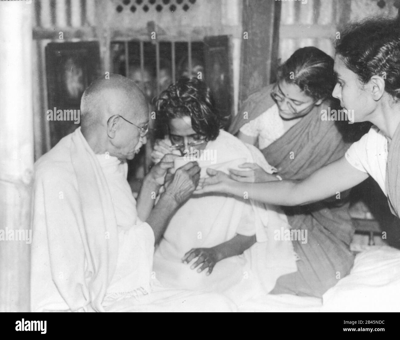 Mahatma Gandhi que ofrece jugo a ayunar asociado rompiendo rápido, India, Asia, enero de 1947, antiguo cuadro vintage de 1900 Foto de stock