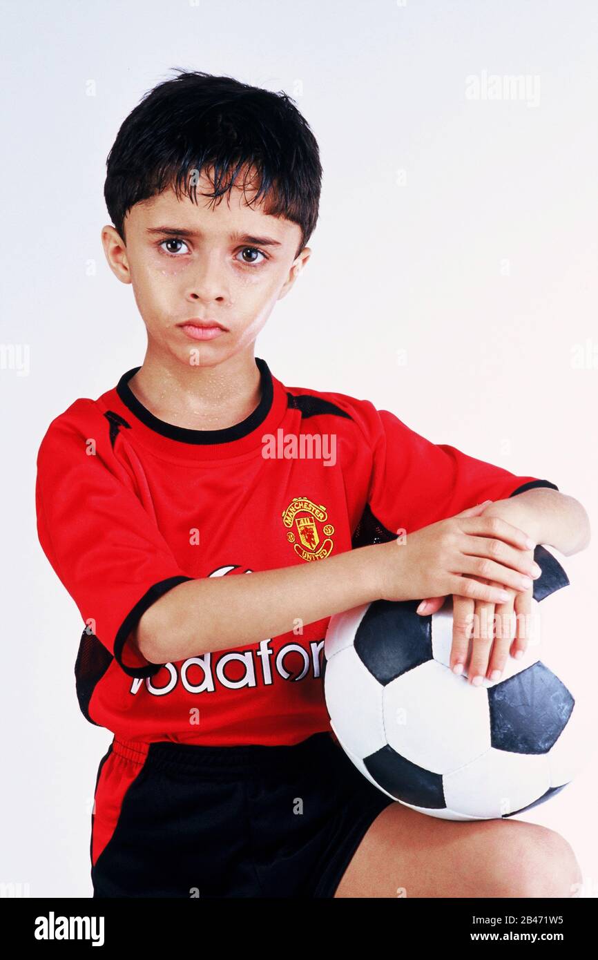 Niño disfrazado de disfraz como jugador de fútbol que sostiene el balón de  pie, MR# Fotografía de stock - Alamy
