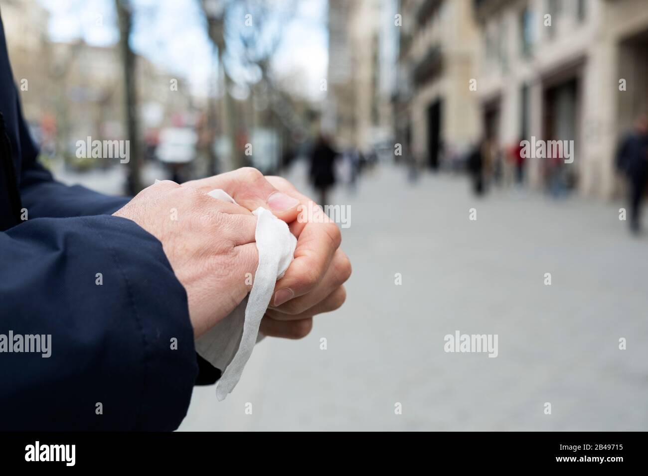 cierre de un hombre caucásico en la calle desinfectando sus manos con un paño húmedo Foto de stock