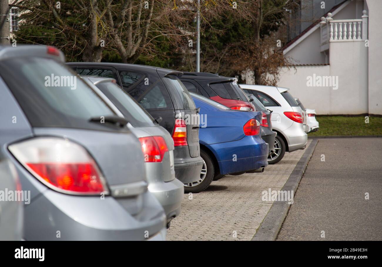los lados de atrás de los coches en plata y rojo en un estacionamiento - foco delantero con fondo borroso Foto de stock
