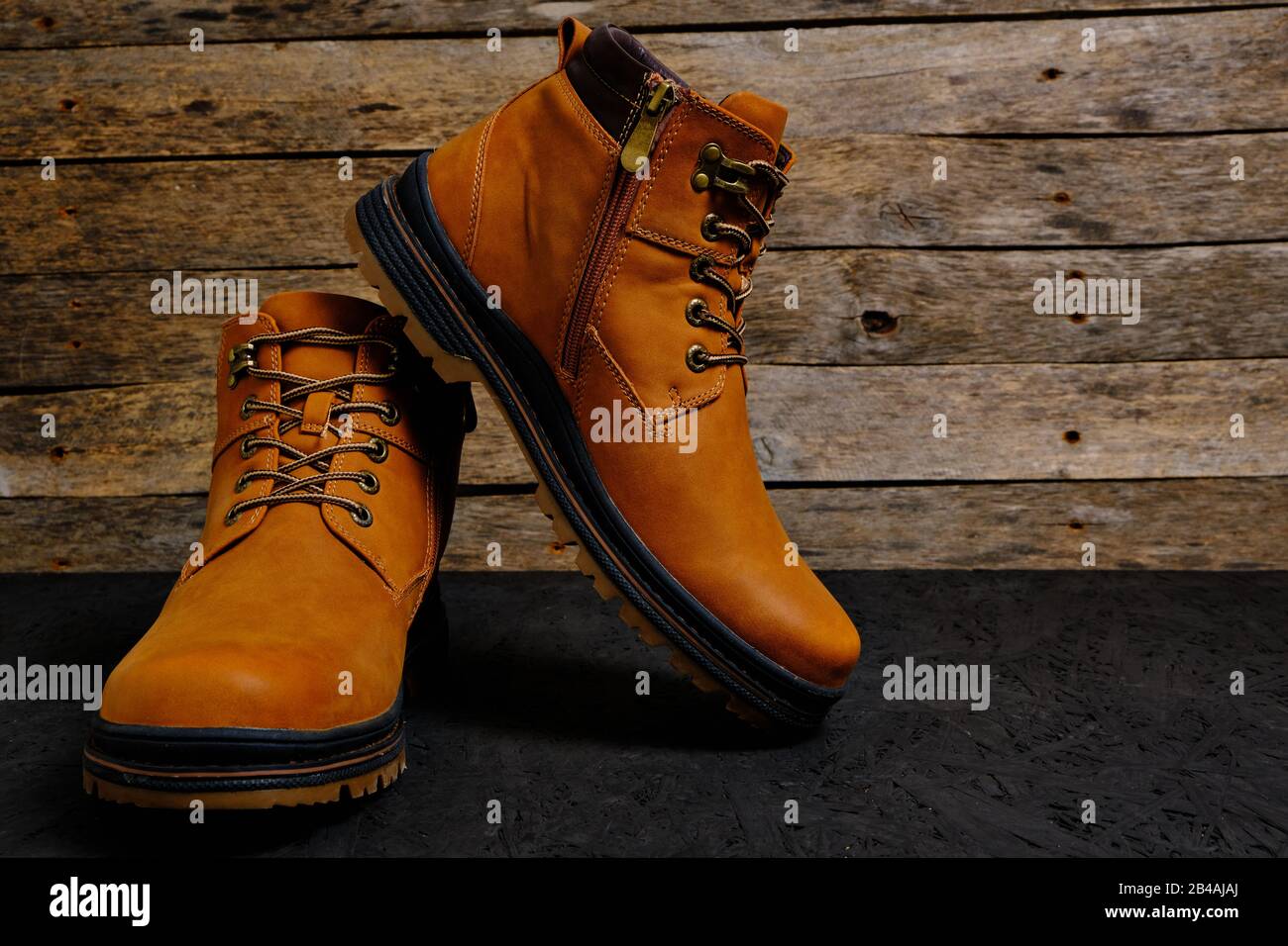 Botas marrones y con cordones sobre un fondo rústico de madera Fotografía  de stock - Alamy