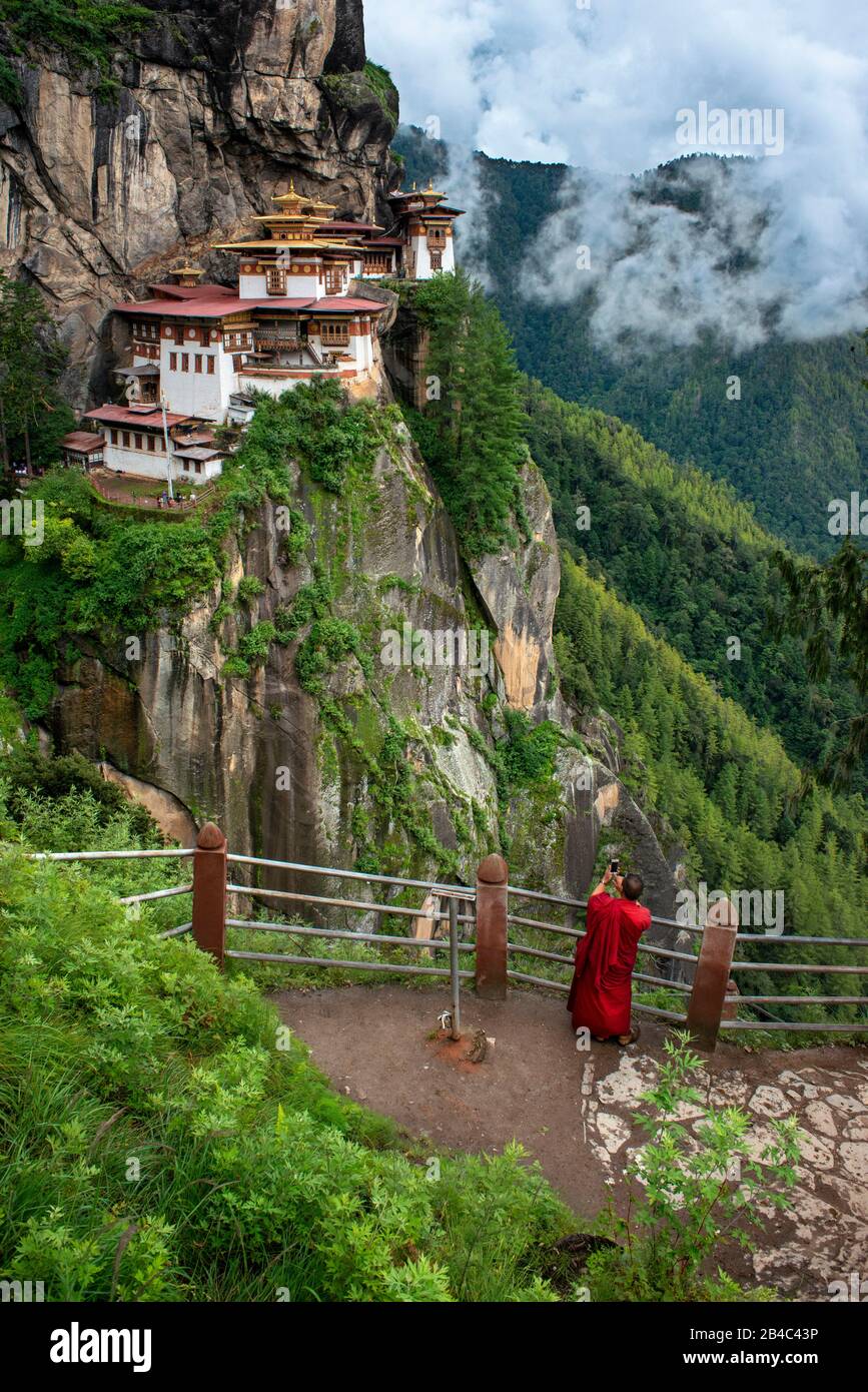 Monje en el monasterio Taktsang Goemba o Tigers Nest en el valle de Paro, Bután, Asia. Paro Taktsang o Taktsang Palphug Monasterio y el nido de tigre es Foto de stock
