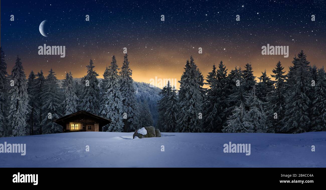 Acogedora cabaña de madera en invierno por la noche Foto de stock