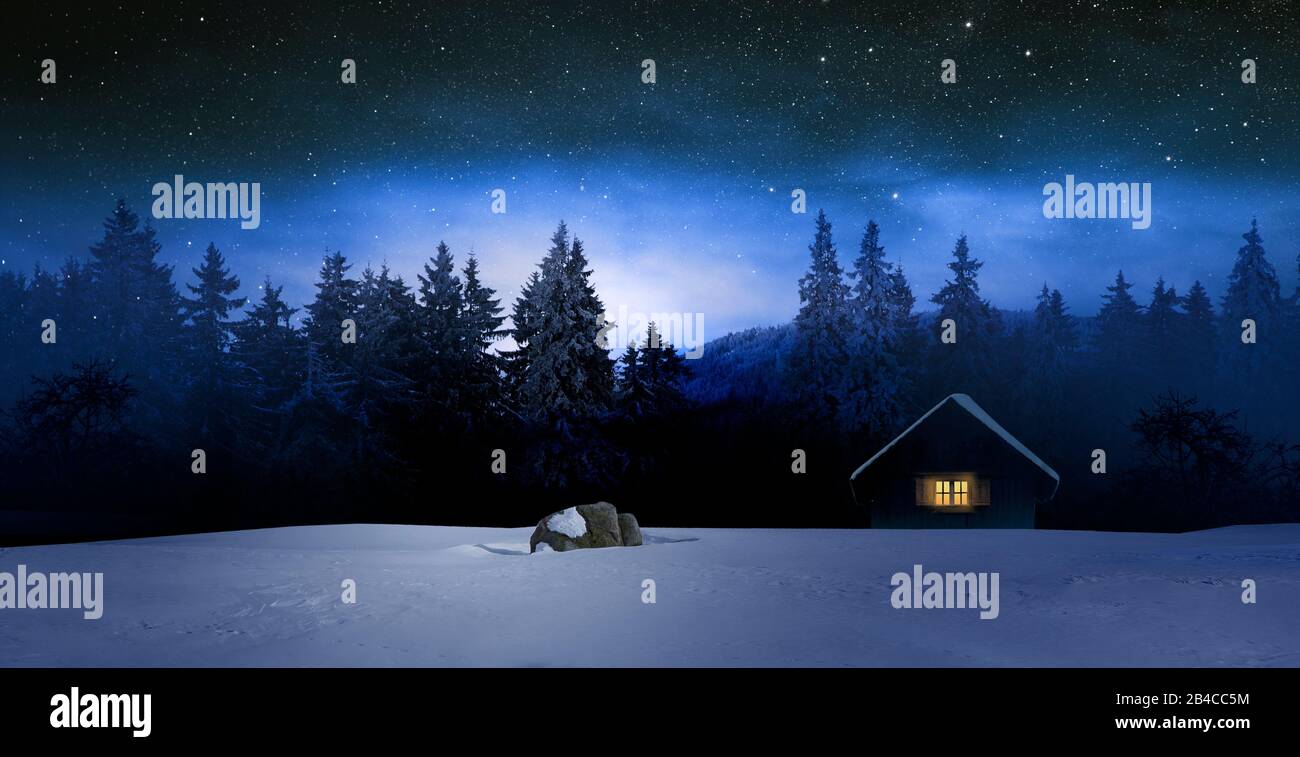 Acogedora cabaña en invierno por la noche Foto de stock