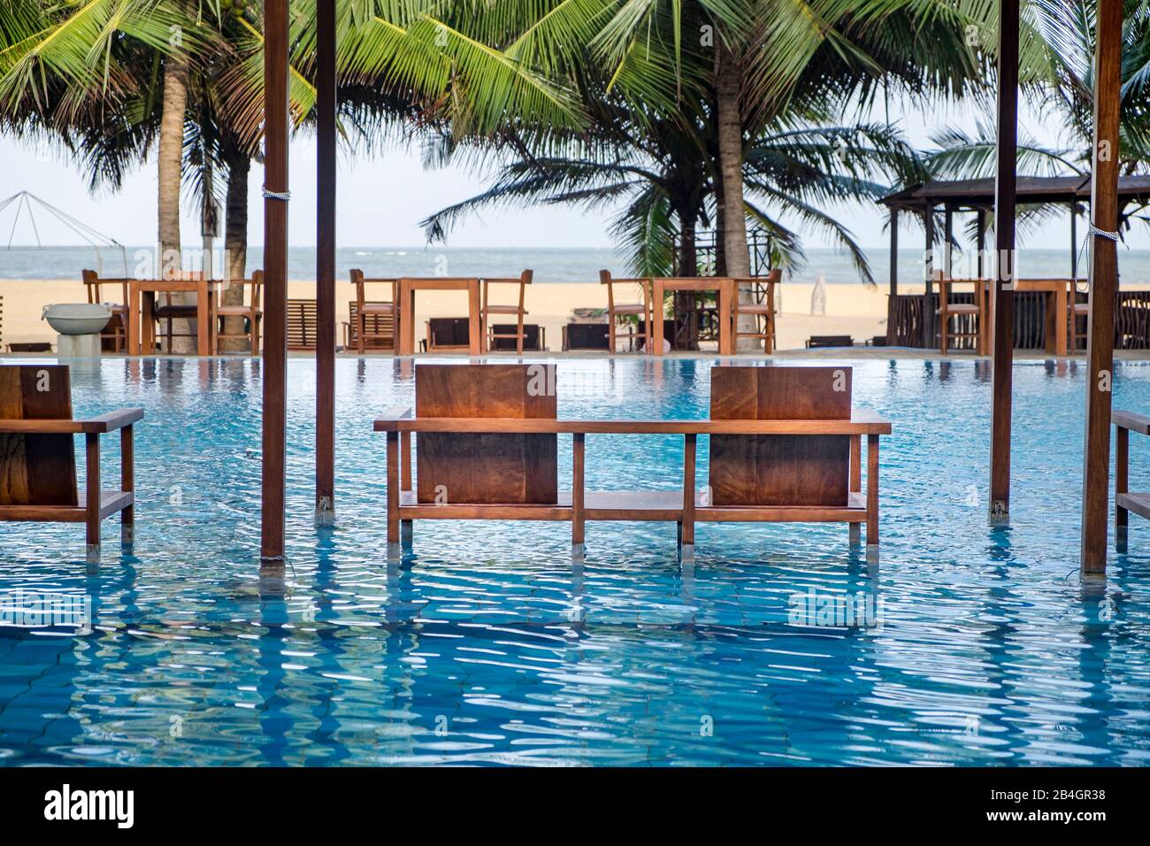 Bancos de madera como asientos en una piscina, hotel Foto de stock