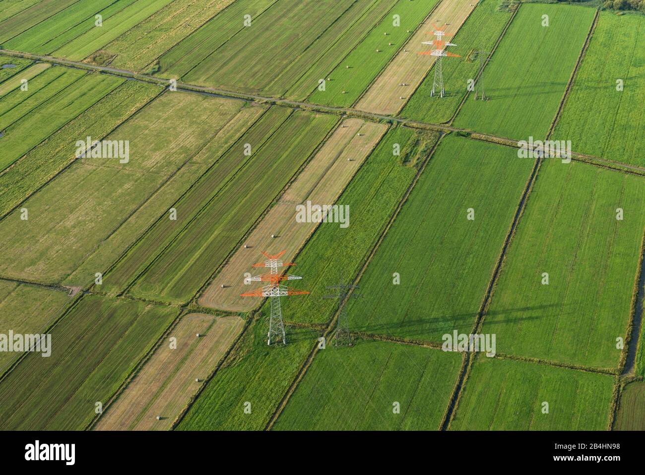 Luftaufnahme von Strommasten auf grünen Feldern Foto de stock