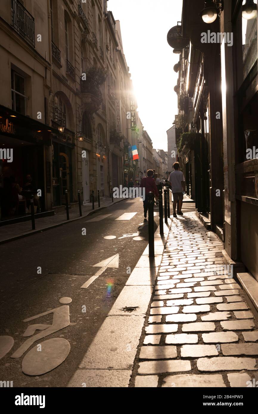 Escena callejera con transeúntes en la deslumbrante luz de fondo, París, Francia, Europa Foto de stock