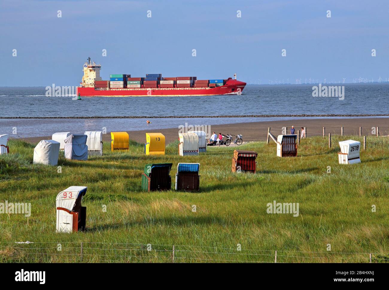 Playa de hierba con sillas de playa y barco contenedor en el estuario de Elbe en el distrito de Döse, Mar del Norte resort Cuxhaven, estuario de Elbe, Mar del Norte, costa del Mar del Norte, Baja Sajonia, Alemania Foto de stock