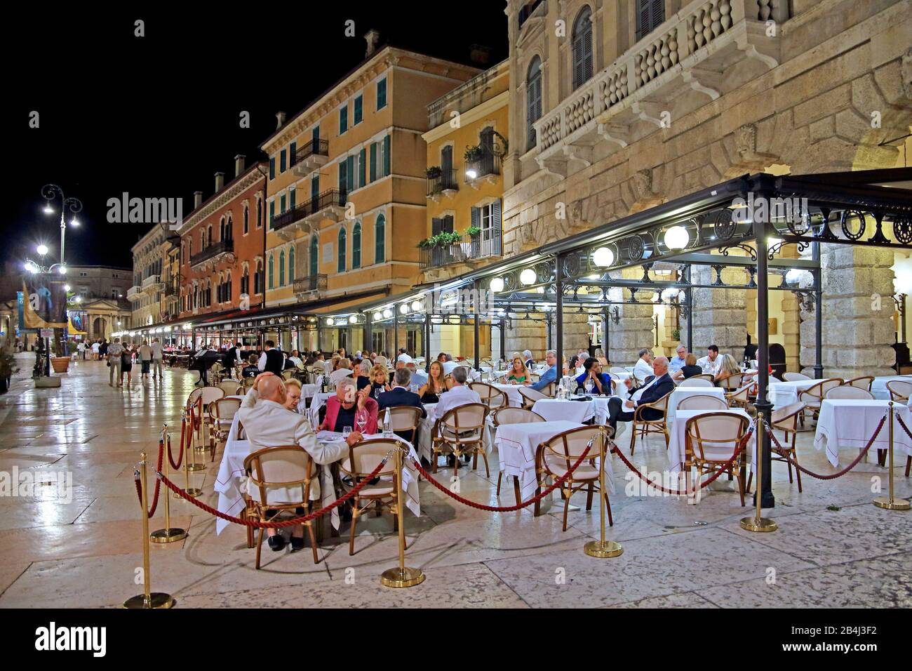 Palazzi en Piazza Bra con terrazas restaurante por la noche, casco antiguo, Verona, Veneto, Italia Foto de stock