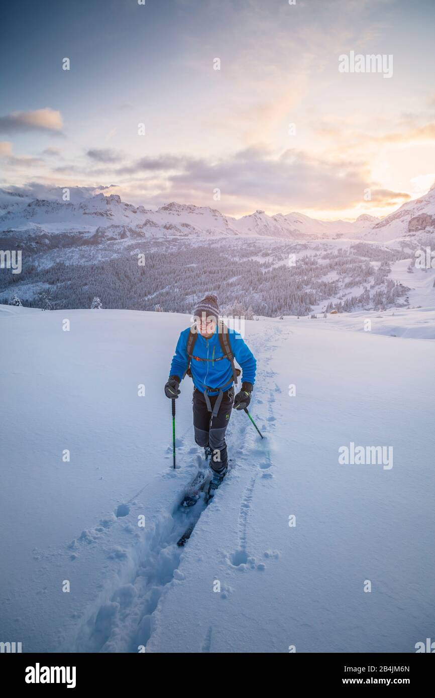 20 años joven montañero de esquí sigue un sendero en nieve fresca al atardecer, Pralongia meseta, Corvara en Badia, Valle de Badia, Tirol del Sur, Italia, Europa Foto de stock