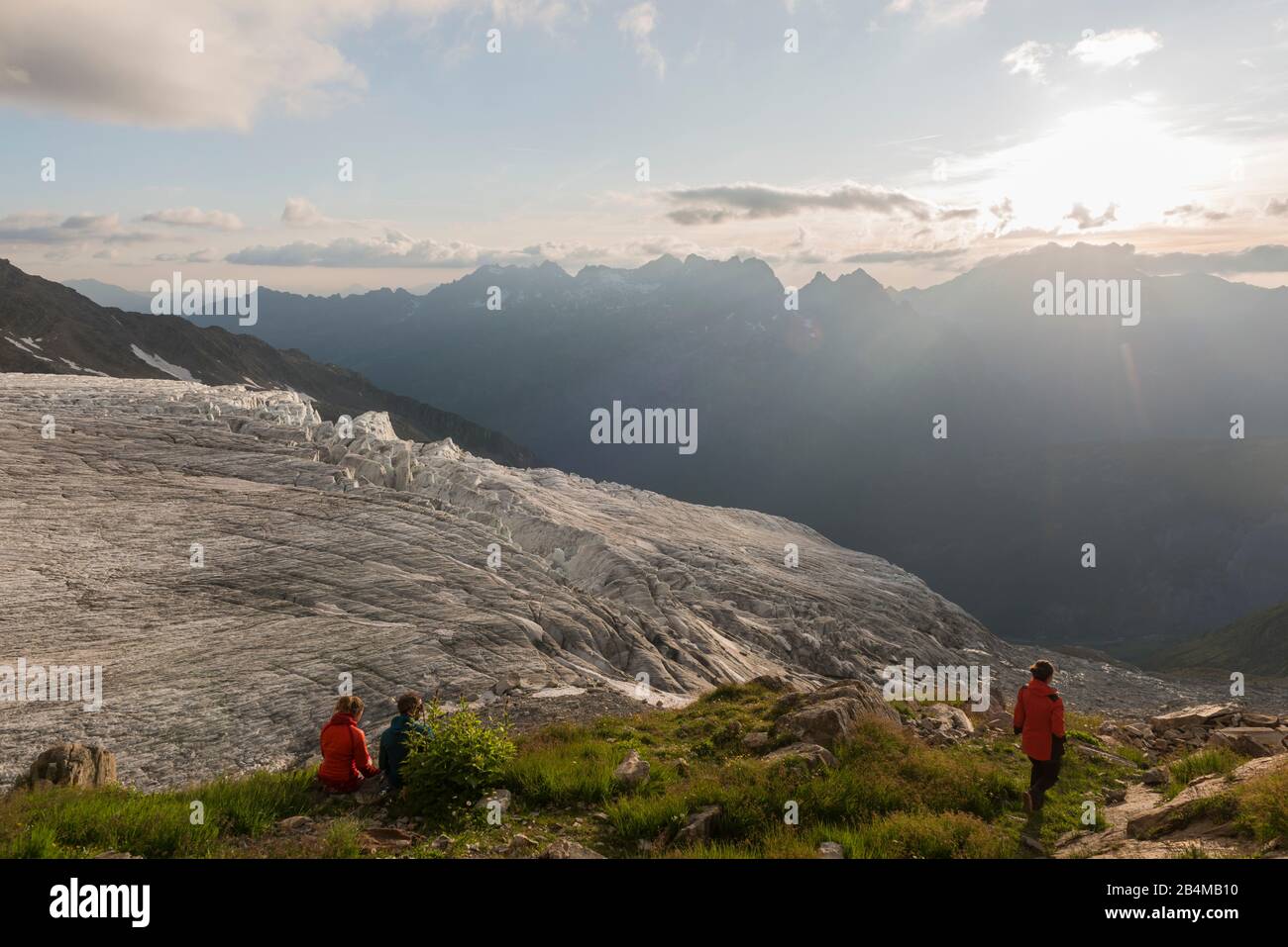 Frankreich, Haute Savoie, Chamonix, Drei Personen beobachten von der Refuge Albert I. den Sonnenuntergang über dem tal von Chamonix und dem Glacier du Foto de stock