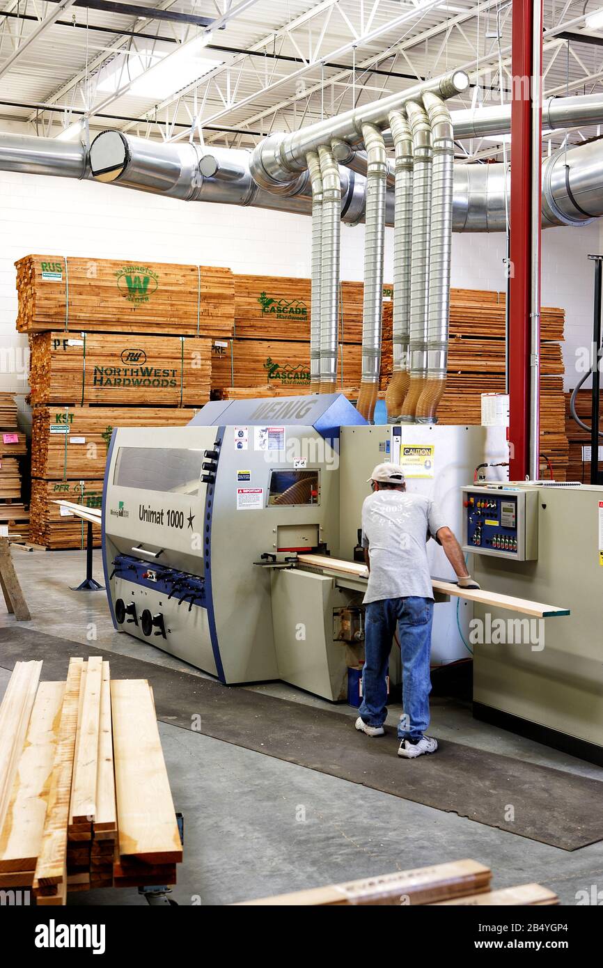 Una máquina para fresado de molduras arquitectónicas. Esta imagen muestra la máquina, el inventario de madera y un sistema de recogida de polvo. Foto de stock