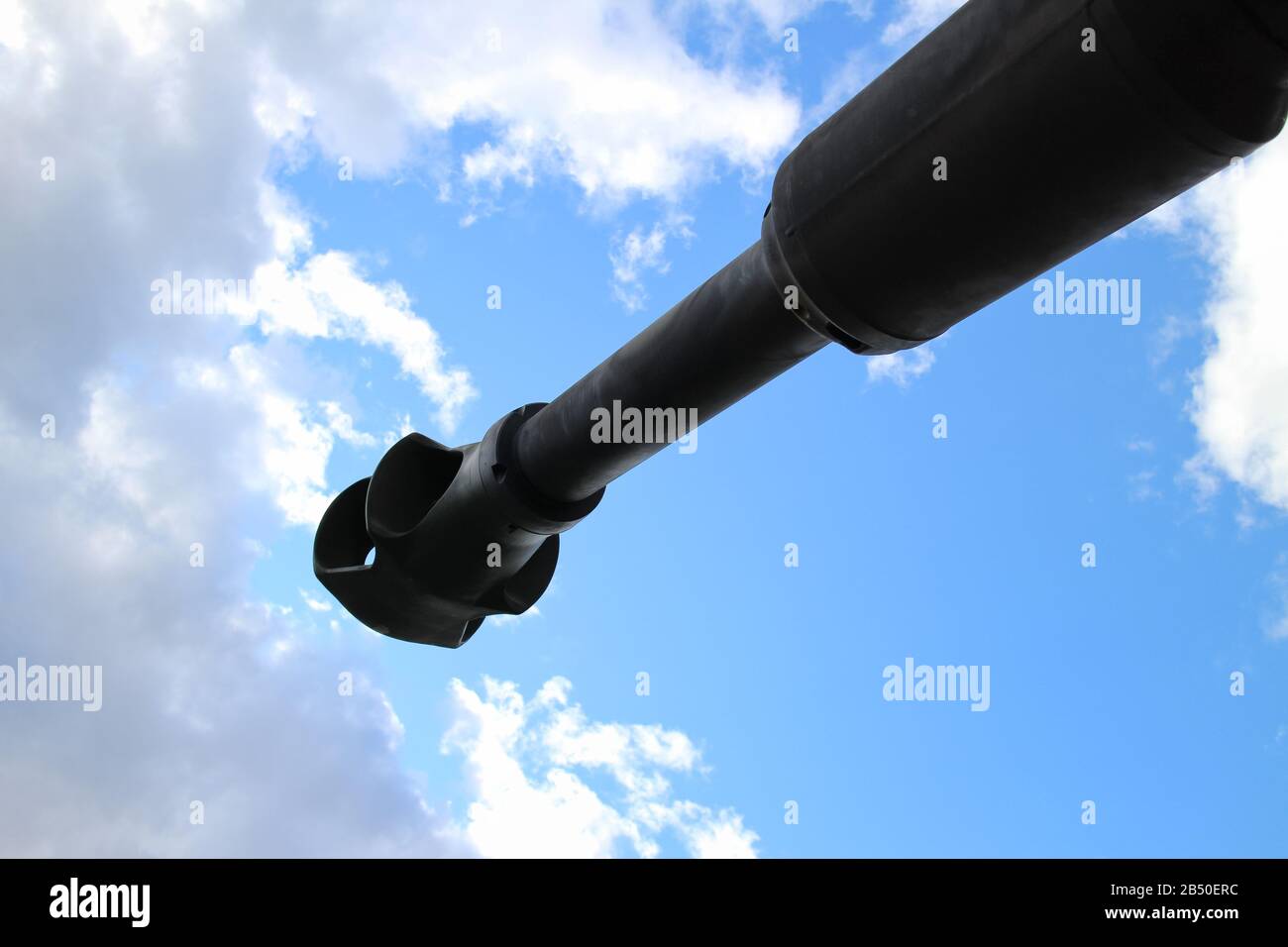 Vista inferior del cañón de tanques contra el cielo azul y las nubes, concepto de guerra y conflicto, paz en la Tierra Foto de stock