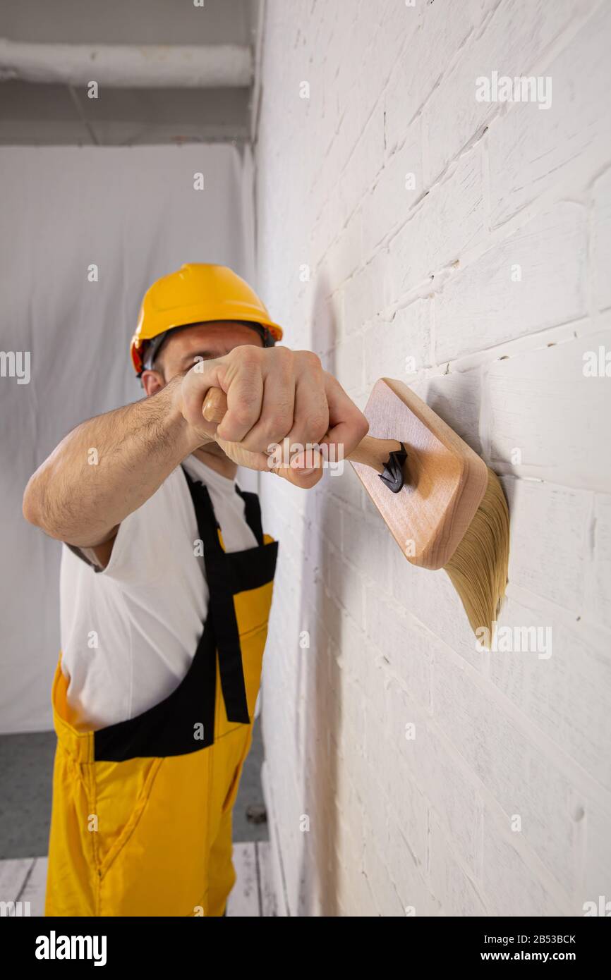 Pintor en un sitio de la construcción mientras que hace su trabajo. Está  vestido con ropa de trabajo especial Fotografía de stock - Alamy